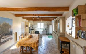 une salle à manger avec une table et une cuisine dans l'établissement La Rose Des Vents, à Modène