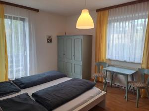 una camera con due letti, un tavolo e finestre di Appartements Kubisko a Keutschach am See Altre 37 foto