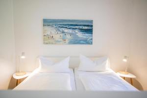 2 camas en una habitación con una pintura de una playa en kleines Versteck- Ein ganz besonderes Domizil inmitten der Friedrichstraße, en Westerland