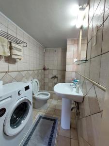 a bathroom with a washing machine and a toilet at Μεζονέτα Χιόνα in Chios