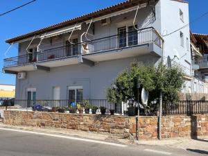 - un bâtiment blanc avec un balcon dans une rue dans l'établissement Μεζονέτα Χιόνα, à Chios