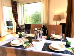 a table with plates and wine glasses on it at Top Apartments Helsinki - Tilkka in Helsinki