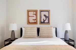 a bed with two lamps and two pictures on the wall at Blueground Chelsea elevator wd nr 8th Ave NYC-1449 in New York