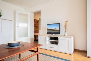 een woonkamer met een tv op een witte kast bij App. Bagehorn 10 in Westerland