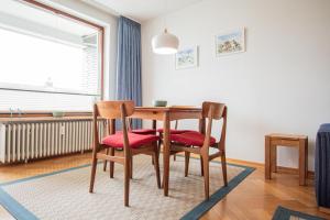 een eettafel met 2 stoelen en een raam bij App. Bagehorn 10 in Westerland