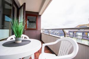een witte tafel en stoelen op een balkon met uitzicht bij App. Bagehorn 10 in Westerland