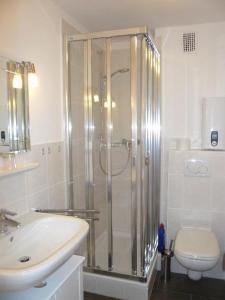 La salle de bains est pourvue d'une douche, de toilettes et d'un lavabo. dans l'établissement App. Hölscher 21, à Westerland