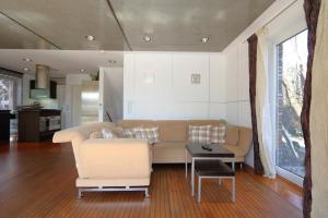 ein Wohnzimmer mit einem Sofa und einem Tisch in der Unterkunft App. Hookipa EG/UG in Westerland