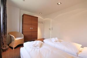ein Schlafzimmer mit 2 Betten und Handtüchern darauf in der Unterkunft App. Hookipa EG/UG in Westerland
