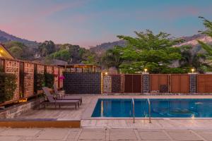 a house with a swimming pool and a fence at Hillside Resort Lonavala - Pawna - Mountain View in Lonavala