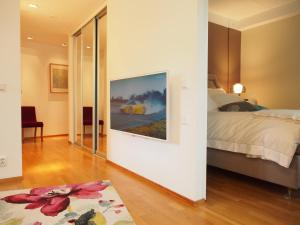 1 dormitorio con 1 cama y una pintura en la pared en Top Apartments Helsinki - Tilkka, en Helsinki