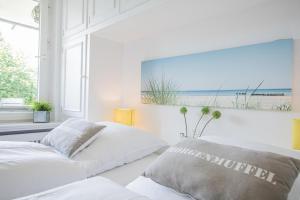2 Betten in einem Schlafzimmer mit Blick auf den Strand in der Unterkunft Sylt-to-Hus - Gartenstraße 4f in Westerland