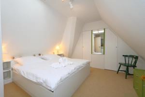 カイトゥムにあるKlagges - Keitumのベッドルーム(白いベッド1台、緑の椅子付)