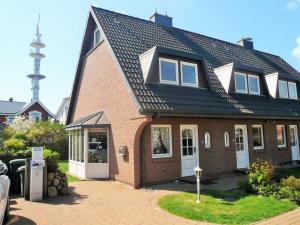 uma grande casa de tijolos com um telhado preto em Haus Freia - für den perfekten Familienurlaub em Westerland