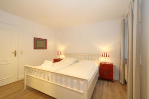 um quarto branco com uma cama branca e 2 candeeiros em Haus Freia - für den perfekten Familienurlaub em Westerland