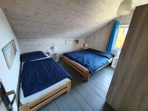 1 dormitorio con 2 camas en una habitación de madera en Domki na Hamaku en Władysławowo