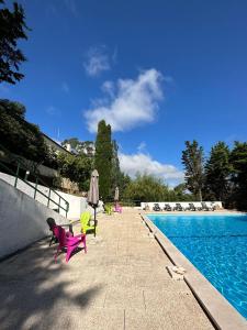 een zwembad met stoelen en tafels en een pinkvisorvisor bij Quinta dos Encantos "Entire Villa" in Pêro Moniz