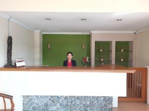 una mujer de pie detrás de un mostrador en una habitación en Hotel Catur Putra, en Magelang