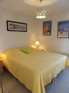 1 dormitorio con 1 cama amarilla grande en una habitación en St Cyprien coup de coeur vue sur la mer, en Saint-Cyprien