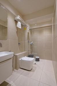 a bathroom with a toilet and a sink and a shower at Exora Inn in Ahmedabad