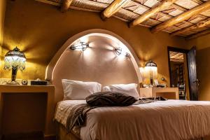 sypialnia z dużym łóżkiem z białą narzutą w obiekcie Kasbah Hotel Xaluca Arfoud w mieście Arfud