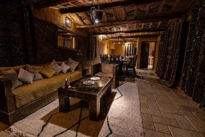 - un salon avec un canapé et une table dans l'établissement Kasbah Hotel Xaluca Arfoud, à Erfoud