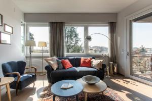 uma sala de estar com um sofá azul e uma grande janela em Riviera Views Apartment by Welc(H)ome em Treviso