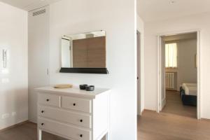uma cómoda branca num quarto com um espelho em Riviera Views Apartment by Welc(H)ome em Treviso