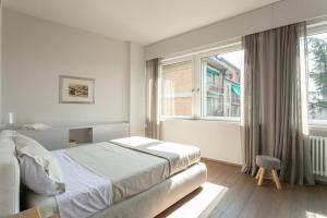 um quarto branco com uma cama e uma janela em Riviera Views Apartment by Welc(H)ome em Treviso