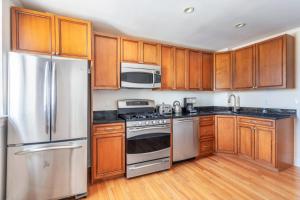 a kitchen with wooden cabinets and stainless steel appliances at Floor Harvard Sq 2BR w Gym Elevator BOS-378 in Cambridge