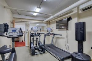 un gimnasio con dos máquinas de correr y un televisor en Floor Harvard Sq 2BR w Gym Elevator BOS-378, en Cambridge