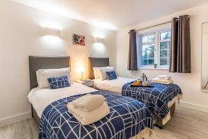 een slaapkamer met 2 bedden met blauwe en witte lakens bij The Faculty by Celador Apartments in Reading