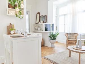 a white kitchen with a table and a living room at Hans Hubert Villa in Haapsalu +69 photos