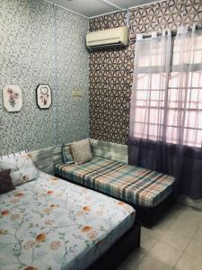1 dormitorio con 2 camas y ventana en E&Y HOMESTAY en Kuala Rompin