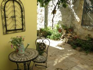een tafel en twee stoelen en een tafel met bloemen erop bij Courtyard Suite, Artists' Quarter, Tzfat in Safed