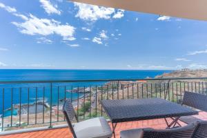 a balcony with a table and chairs and the ocean at Sunspot Reis Magos with sea view in Caniço