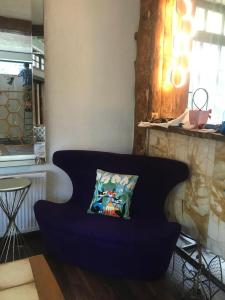 una sedia blu con un cuscino in una stanza di Pensiunea Tihna a Râu de Mori