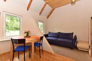 uma sala de estar com uma mesa e um sofá em Namas su vaizdu į ežerą "Giliaus Nendrė" em Tytuvėnai