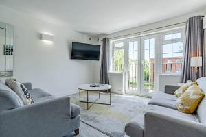 a living room with two couches and a tv at The Faculty by Celador Apartments in Reading