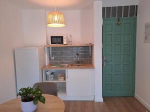 a kitchen with a green door and a table at Hotel Mediterrani Express in Calella