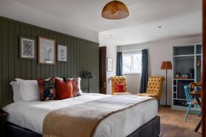 a bedroom with a large bed and two chairs at The Bridge Hotel in Chertsey