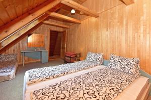 1 dormitorio con 1 cama en una habitación con paredes de madera en Namas su vaizdu į ežerą "Giliaus Nendrė" en Tytuvėnai