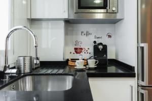 a kitchen with a sink and a microwave at tuGuest Dílar Apartment in Granada