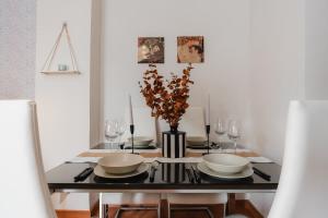 a dining room table with a vase of flowers on it at tuGuest Dílar Apartment in Granada