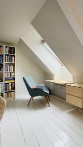 een kamer met een blauwe stoel op een zolder bij ApartmentInCopenhagen Apartment 1594 in Kopenhagen
