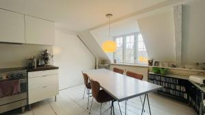 een keuken met een witte tafel en stoelen. bij ApartmentInCopenhagen Apartment 1594 in Kopenhagen
