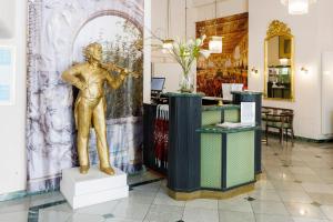 a statue of a man playing a violin in a lobby at Hotel Johann Strauss in Vienna