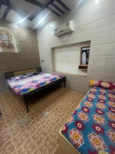 a room with two beds and a mirror in it at Mahesh Guest House Ajmer in Ajmer