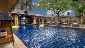 a large swimming pool with chairs and a resort at Talay Naiharn Villa in Rawai Beach