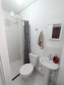a white bathroom with a toilet and a sink at Inovally in Guarulhos